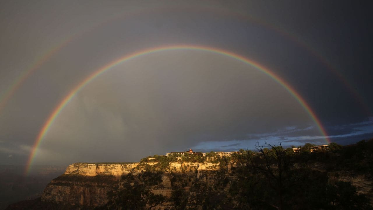 La veille de la randonnée, un double arc-en-ciel brille en soirée au-dessus de l’hôtel El Tovar sur le bord Sud du Grand Canyon.