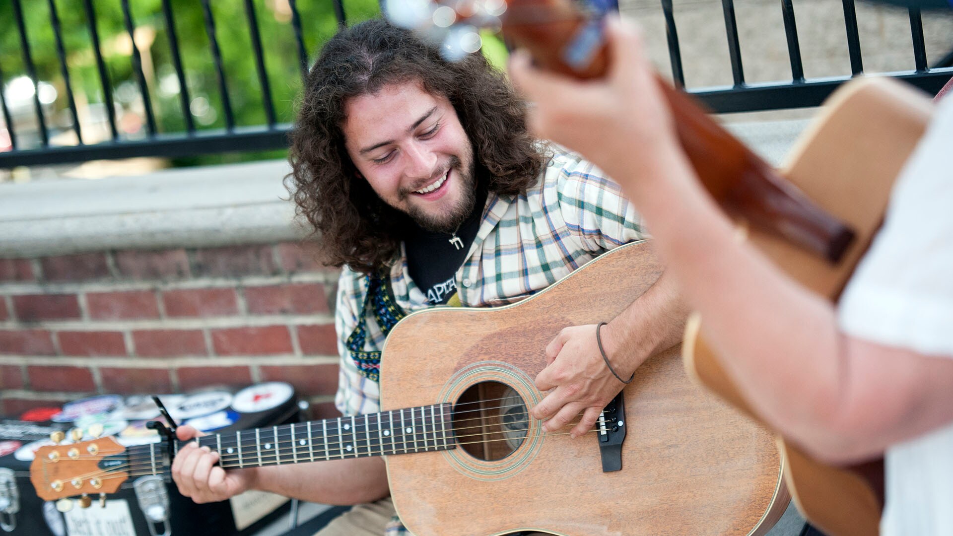 Jake Retting plays guitar along Locust Street in picturesque Floyd, Virginia.