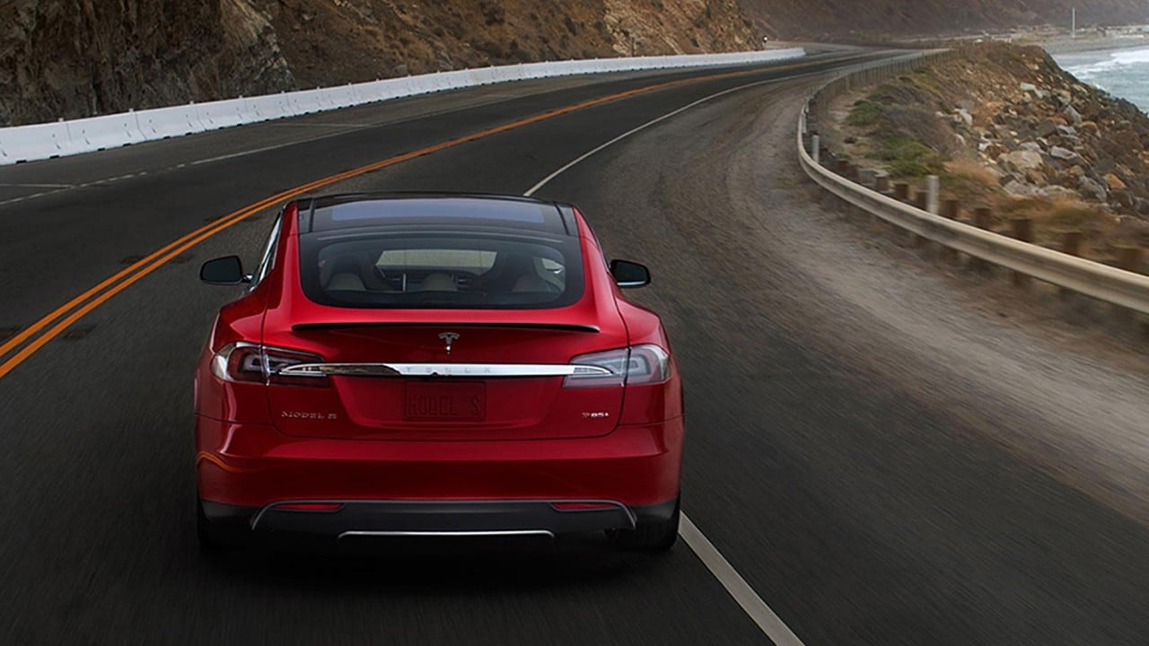 Red Car driving along curvy highway