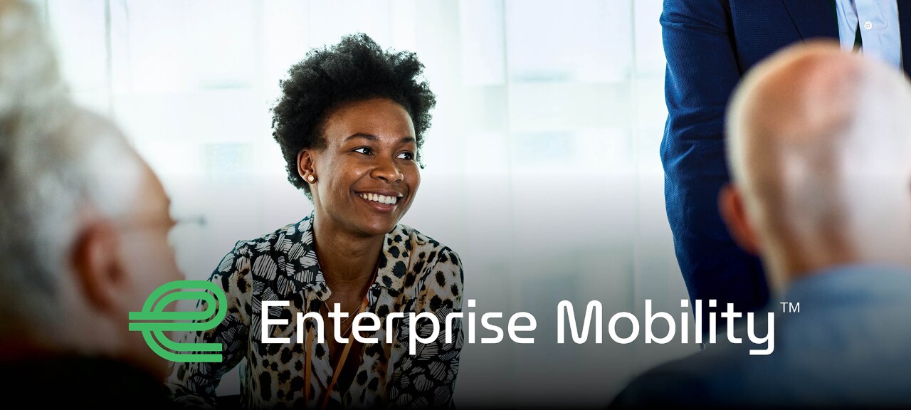 People sitting around a table with the "Enterprise Mobility" log on the bottom fo the photo.