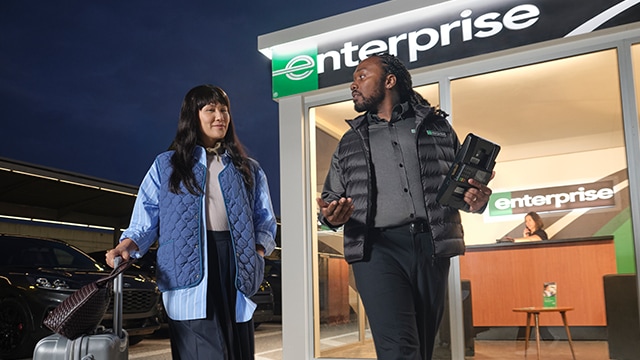 Male enteprise employee walking and talking to a female customer